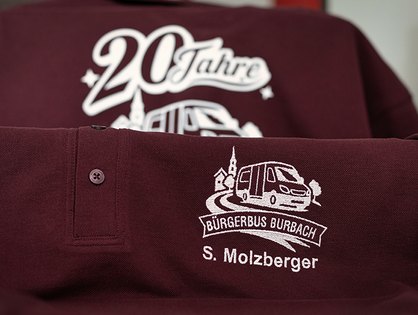 Poloshirts mit besticktem Jubiläumsmotiv und Namenszug für den Bürgerbus Burbach